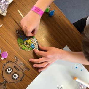 Child's hands making a suncatcher in arts and crafts