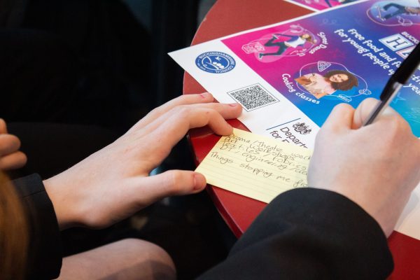 photo of hands writing on a card