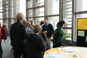 Photo of young people standing and talking with adult